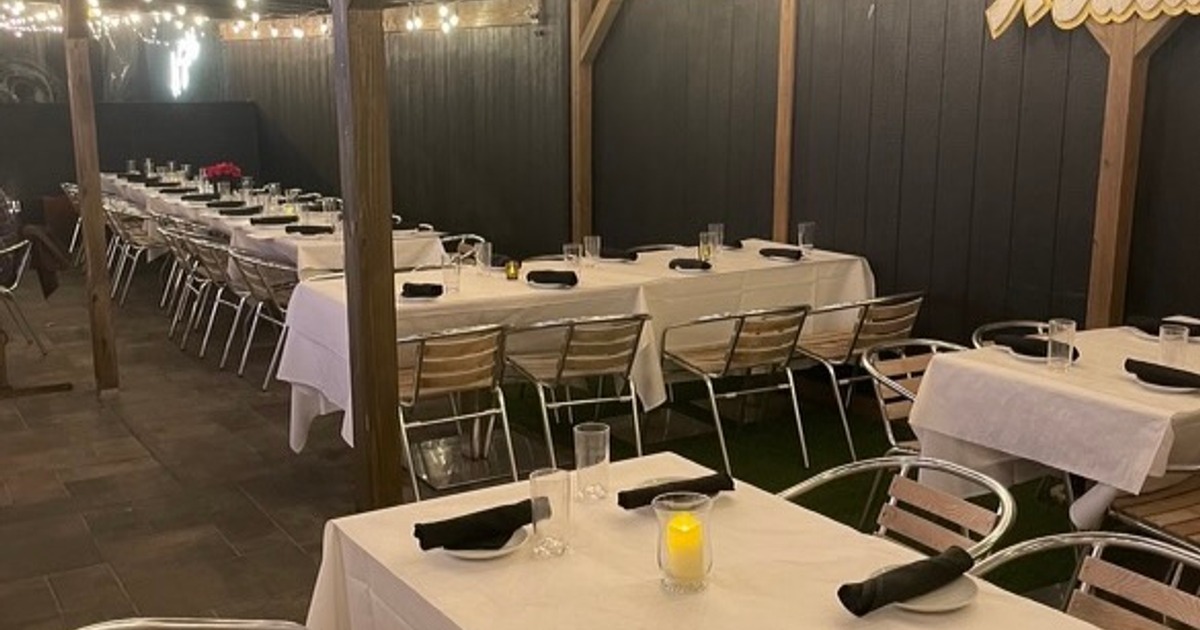 Outdoor dining area, tables and seats arranged and set for dining