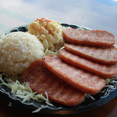 Five pieces of fried spam served with macaroni salad and rice.
