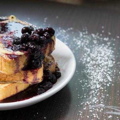 French toast with powdered sugar and cranberry sauce, close up.