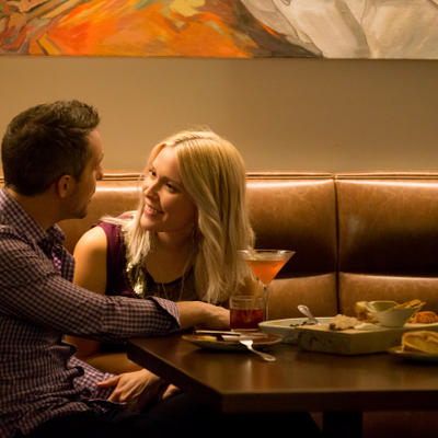 Man and women glazing into each others eyes as they enjoy drinks and food