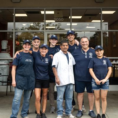 Owner and staff in front of New York Bagel and Deli.