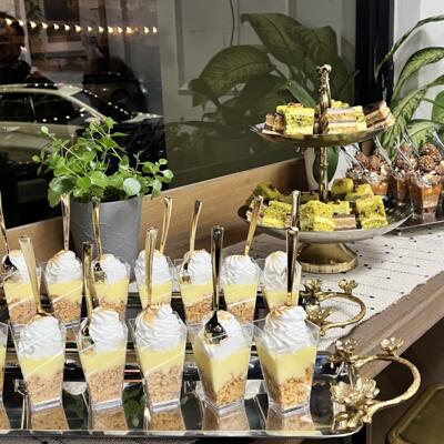 Elegant dessert display with layered parfaits, pistachio cakes, and caramel nut cups.