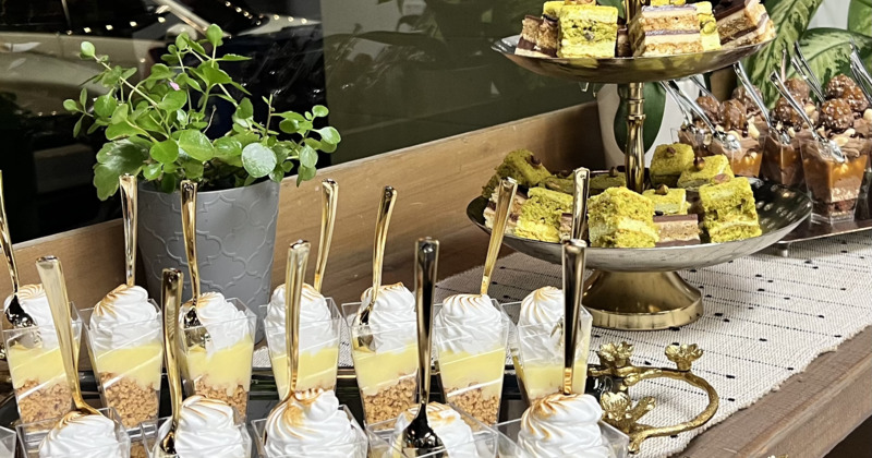 Elegant dessert table with lemon mousse cups and pistachio cakes