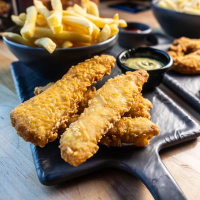 Fried fish served with fries and a dipping sauce.