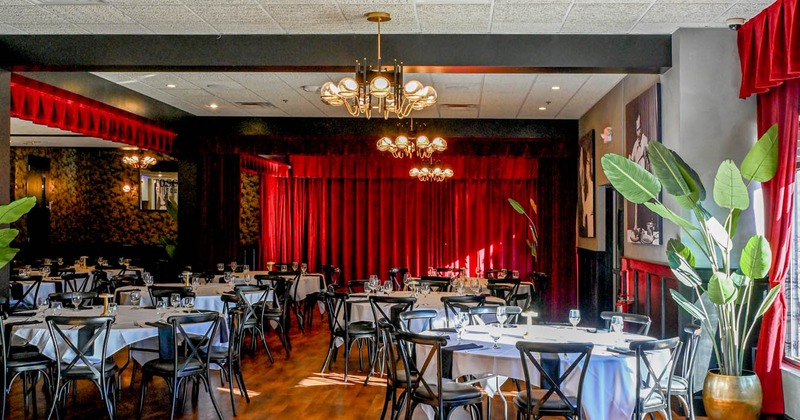 Interior, tables with white tablecloths and black chairs