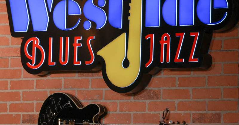 Interior, wall closeup, logo and a hanging electric guitar