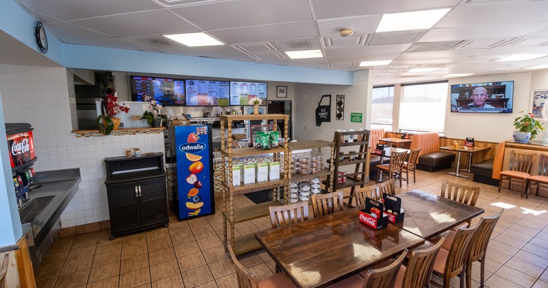 Casual diner interior with wooden tables and digital menu boards