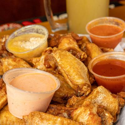 Wing sampler plate with four side sauces.