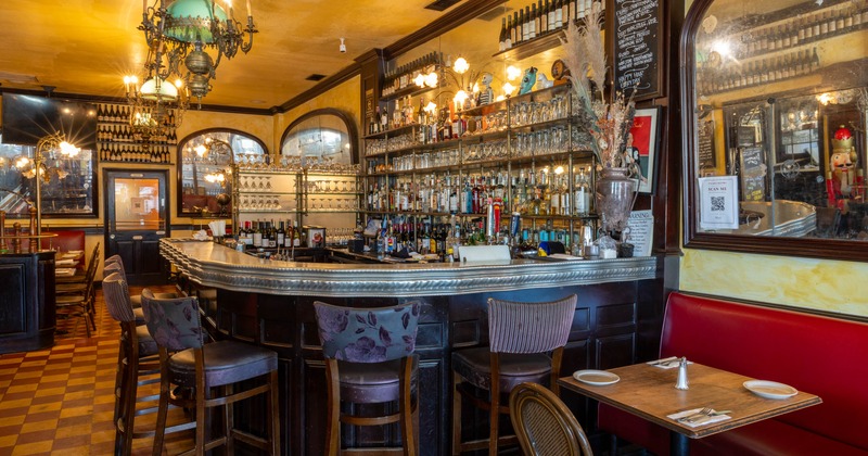 Interior, bar area, wooden front and top bar with vintage stools, large drinks wrack