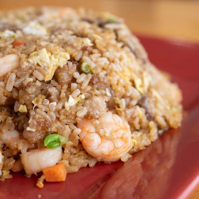 Portion of shrimp and mixed vegetable fried rice, close-up.