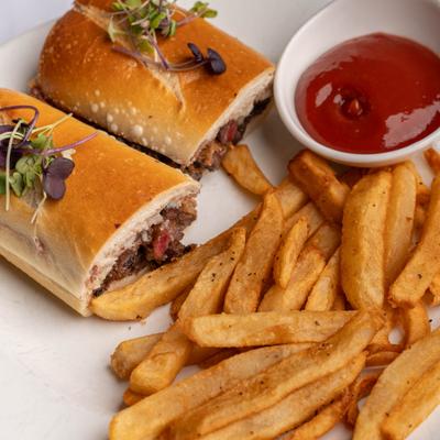 Steak Sandwich served with fries and a dipping sauce.