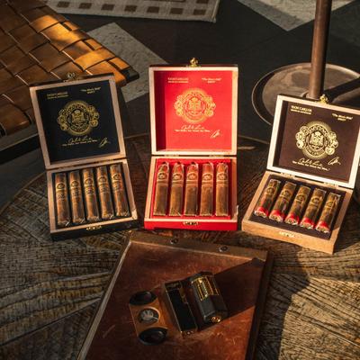 A table with cigar boxes, cigar cutter, and lighter on it