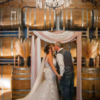 Wedding Couple kissing in the Barrel Room at Next Chapter Winery.