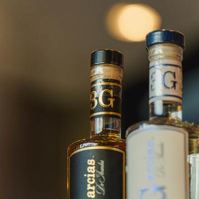 Close-up of two tequila bottle tops with black and white labels.