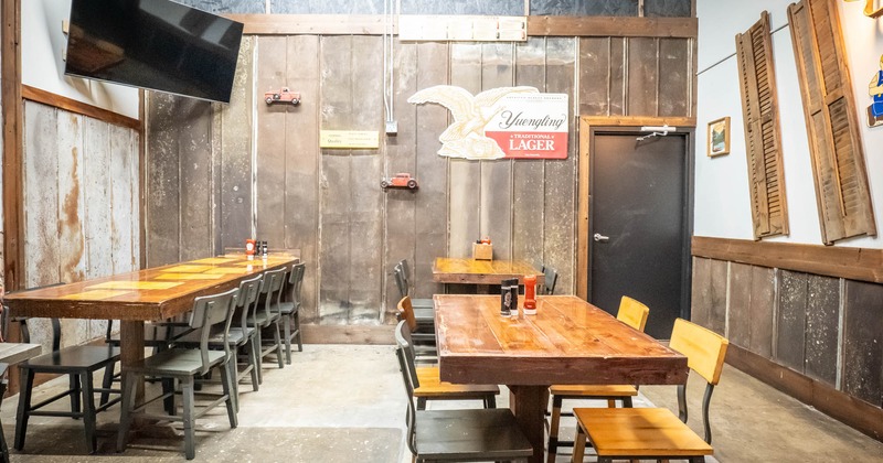 Interior, regular tables for four, long community table setup for eight, TV in the corner