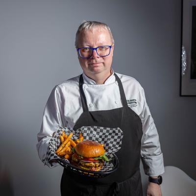 Chef holding a burger basket with fries.