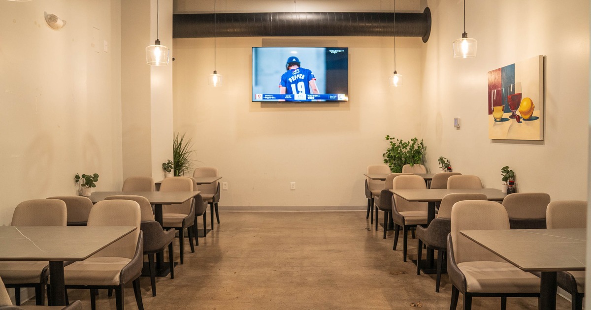 Cozy restaurant interior with beige chairs, tables, and hanging lights