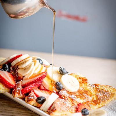 Golden syrup pours onto a Fruity French toast plate.