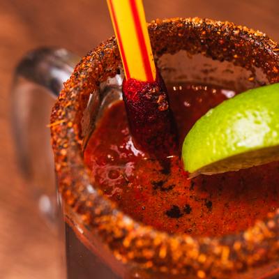 Michelada served in a rimmed mug, garnished with a lime wedge.