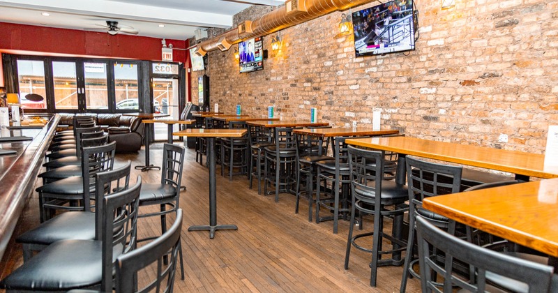 Interior, wide view of seating area, TV screens on the wall