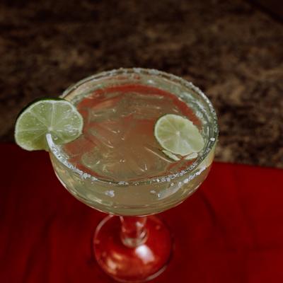Margarita in salt-rimmed coupe glass, garnished with lime wheels.