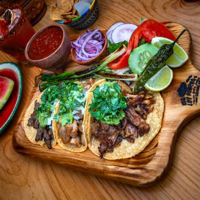 Chicken, steak, and pork tacos, with onion and cilantro.