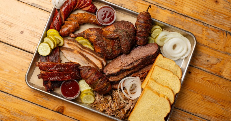 Smoked brisket served on a tray with creamed corn and BBQ sauce