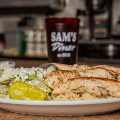 Grilled chicken plate with rice and salad.