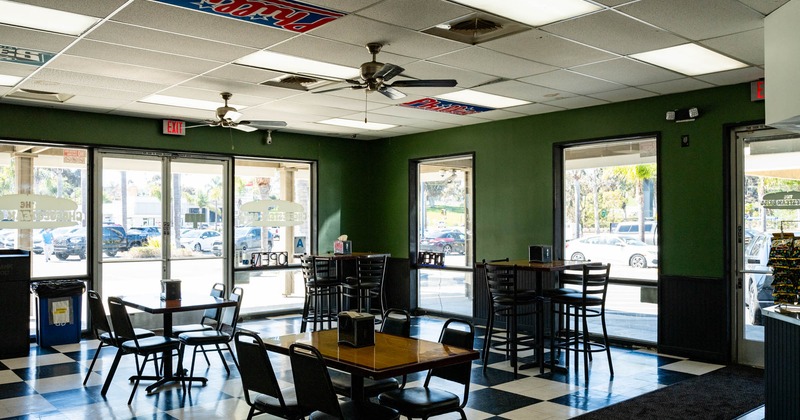 Interior, dining area, high and regular tables with chairs, black and white checkered tiles