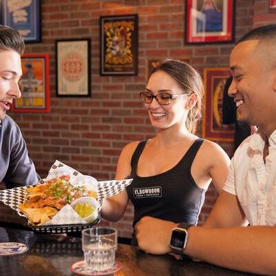 Staff member serving food, guests enjoying, drinking