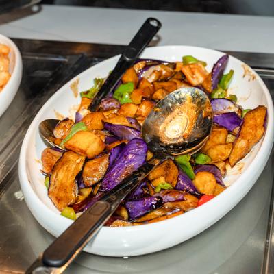 Stir-fry featuring purple eggplant, peppers, and savory sauce.