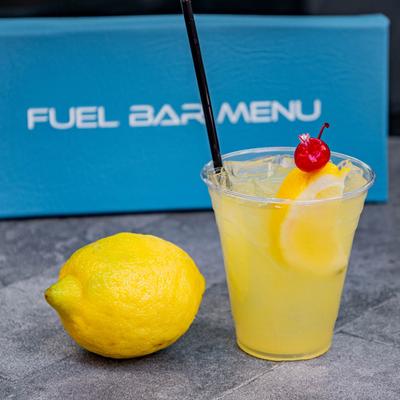 A served tropical lemonade and a whole lemon next to it.