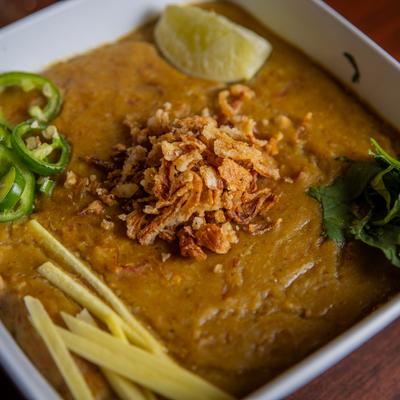 Haleem dish, with spicy porridge, grains, and meats.
