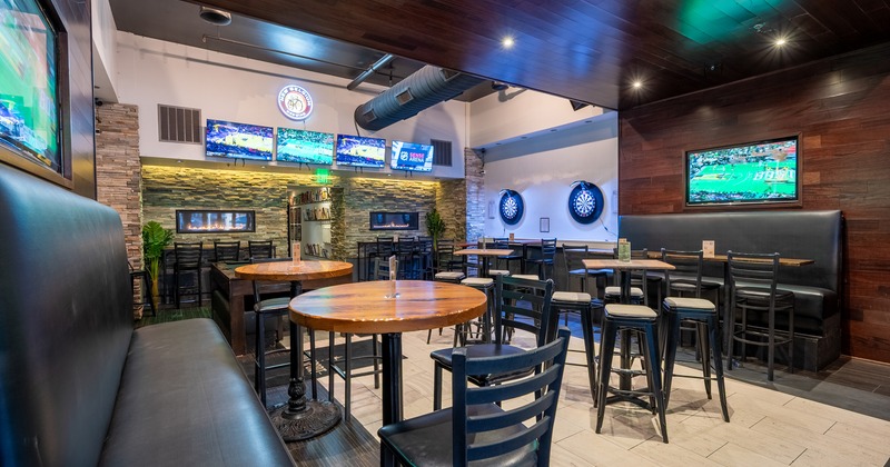 Interior of a modern sports bar with bar stools and high tables
