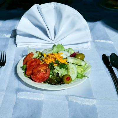 House sa;ad, served with cutlery and a napkin.