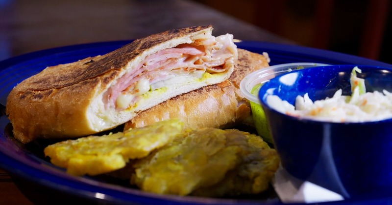 Kiwi's Cuban sandwich with fried green plantains, coleslaw, and Island sauce