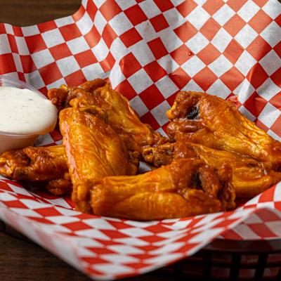 Buffalo Wings served with a dip on the side.