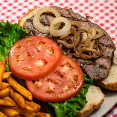 Steak and cheese sandwich with lettuce, tomatoes and grilled onions.