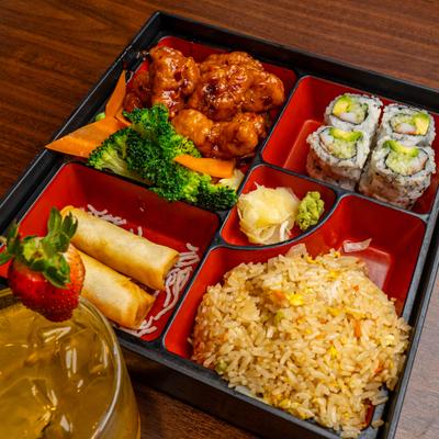 General Tso's Chicken Bento Box featuring a main dish, sushi, appetizers, and a side of rice.
