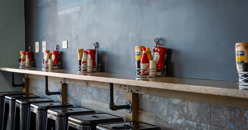 Interior, levitating marble top bar plank with condiment trays and metal stools