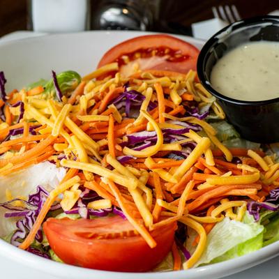Dinner Salad, with lettuce, red cabbage, tomato, cucumber, carrots, cheddar, and dressing.