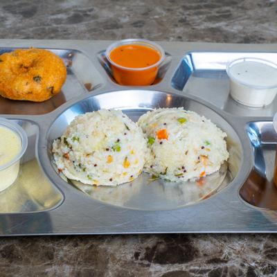 Steamed fermented rice cakes served with a lentil fritter, and various chutneys.