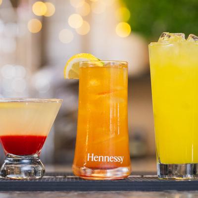 Three different cocktails sit on a bar mat.