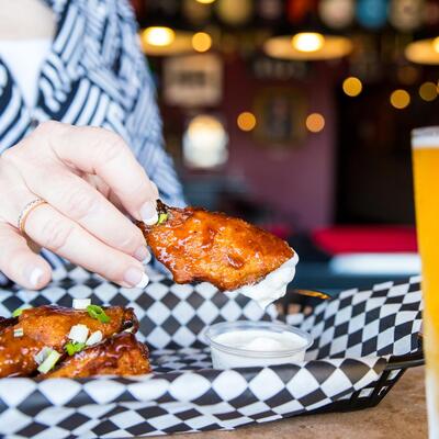 Guest eating teriyaki wings with dip