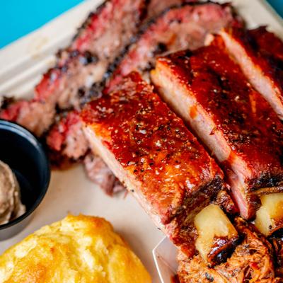 Barbecue platter features slow-smoked pork ribs, pulled pork, brisket and sides.