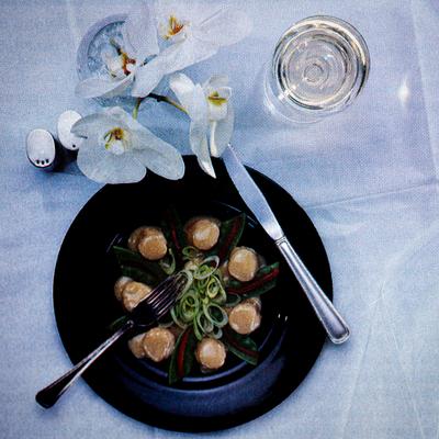 Scallops, white wine, and orchids on a table