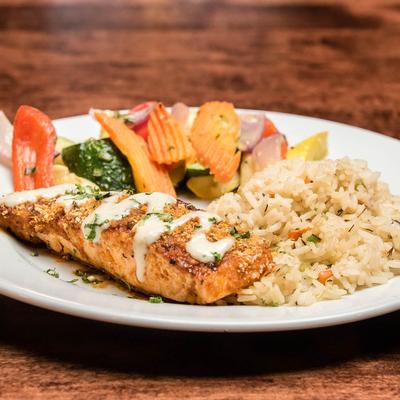 Buffalo glazed salmon, served with rice, and mixed vegetables.