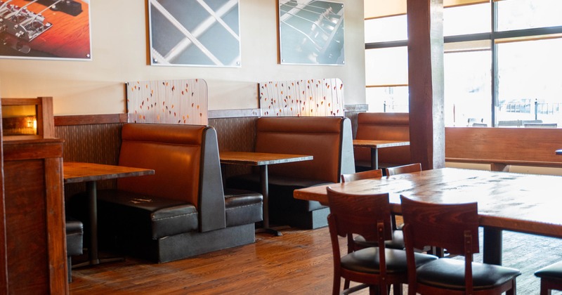 Interior - brown leather booths, wooden tables; framed photographs on the wall; large windows