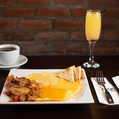 Omelet served with sweet potatoes and pita, cup of coffee and orange juice.