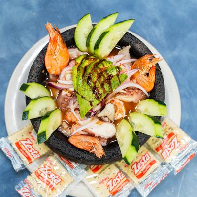 Seafood molcajete with scallop, shrimp, octopus, and avocado, served with crackers.